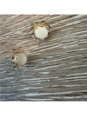 14k gold earrings with floral design and a white cabochon